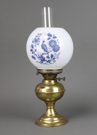 A gilt metal oil lamp with opaque glass shade decorated a bird, complete with clear clear glass chimney 47cm h 