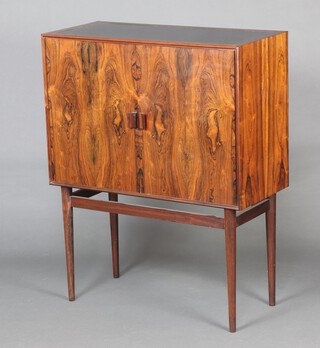 In the manner of H W Klein for Bramin, a mid Century, 1960's, Danish rosewood drinks cabinet, the interior fitted simple shelving and 5 moulded bottle rests  106cm h x 86cm w x 36cm d.  Supplied with a Cites Article 10 certificate,  No. 24GBA10VG2E6E