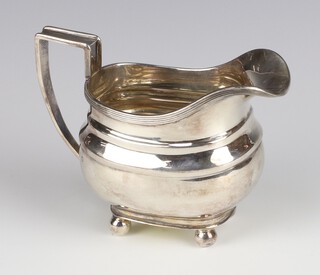 A Georgian design silver cream jug with reeded decoration on bull feet, Sheffield 1931, 181 grams 