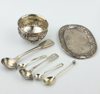 An Indian white metal repousse table salt decorated with village scene, 4 condiment spoons and a repousse oval dish, 77 grams 