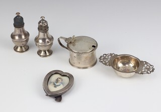 A Victorian silver heart shaped photograph frame 7cm, a pair of peppers, a mustard and tea strainer 