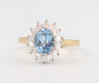 An 18ct yellow gold oval topaz and diamond ring, the centre stone approx. 1ct surrounded by 14 brilliant cut diamonds each approx. 0.03ct, 4 grams, size L 