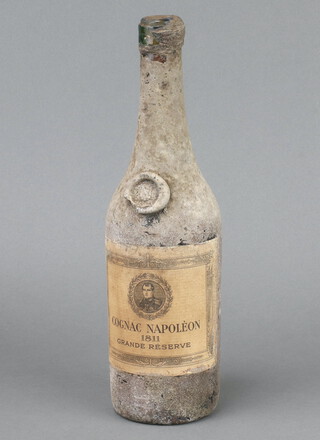 A rare and early bottle of Napoleon 1811 Grand Reserve Cognac, the bottle is coated with a resin? so we cannot see the level of the cognac, looking to the base the colour of the cognac is good and the bottle feels to be filled to a good level 