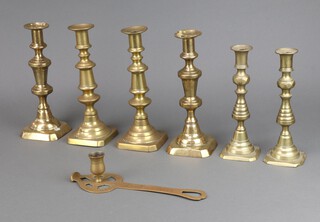 A pair of 19th Century brass candlesticks with ejectors 23cm x 10cm x 10cm and 22cm x 8cm x 8cm, 2 other brass candlesticks and a brass chamber stick marked Good Luckin Both Edinburgh 