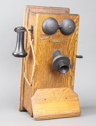 A Western Electric wall telephone contained in an oak case 24cm x 51cm x 23cm 