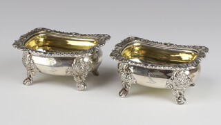 A pair of George IV rectangular silver table salts with shell and scroll rims and engraved armorial,  on scroll feet with gilt interiors, London 1822, makers mark rubbed  