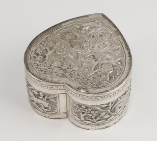 An Indian white metal heart shaped repousse box decorated with animals in a village scene, 8cm, 121 grams 