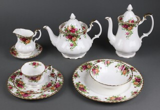 A 66 piece Royal Albert Old Country Roses pattern tea service comprising 9 dinner plates (2 seconds), 10 side plates (2 seconds), 10 tea plates, 10 cups, 10 saucers (2 seconds, 1 cracked), oval plate, rectangular bread plate, 8 bowls, 2 shaped dishes (seconds), specimen vase, tea pot, coffee pot (second), sugar bowl (cracked) and cream jug 