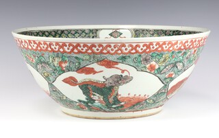 A 19th Century Chinese famille verte bowl decorated with panels of Shi Shi, the interior with a dragon amongst clouds 38cm 