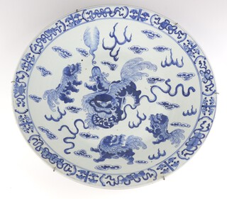 A 19th Century Chinese blue and white charger decorated with Shi Shi and dragons amongst clouds 47cm 