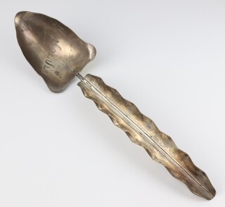 A white metal serving spoon in the form of a leaf, engraved Honolulu 