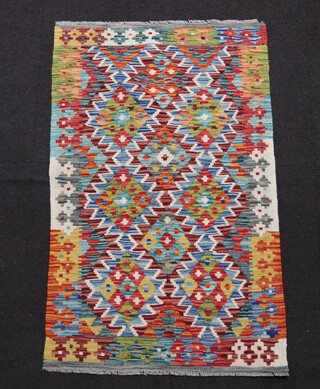 A brown, green and white ground Chobi Kilim with all over geometric design 127cm x  79cm 