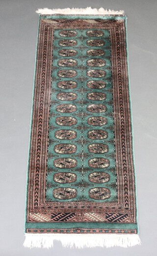 A green and black ground Bokhara runner with 28 octagons to the centre within a multi row border 175cm x 65cm 