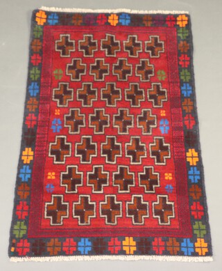 A red and brown ground Belouche rug 123cm x 82cm with cross design 