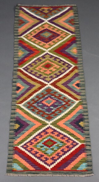 A green, orange and purple ground Chobi Kilim runner with 4 stylised diamonds to the centre 192cm x 64cm 