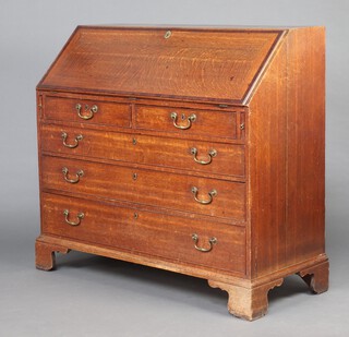 A Georgian oak bureau with crossbanded fall front, the interior fitted, drawers, pigeon holes and a cupboard above 2 short and 3 long drawers 111cm h x 119cm w x 53cm d 