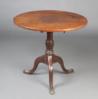 An 18th Century oak and elm snap top tea table, raised on pillar and tripod base 71cm h x 66cm diam. 