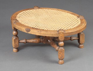 A 17th Century style oval light oak stool with cane seat, raised on turned supports with X framed stretcher 20cm x 50cm x 38cm 