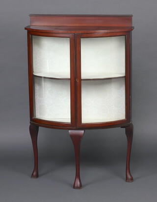 An Edwardian inlaid mahogany bow front display cabinet with raised back, fitted shelves enclosed by a glazed panelled door, raised on cabriole supports 120cm h x 78cm w x 34cm d 