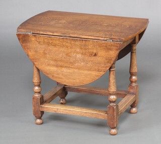 A 17th Century style oval oak drop flap table, raised on turned supports with box framed stretcher 50cm h x 61cm w x 36cm when closed x 85cm when open 