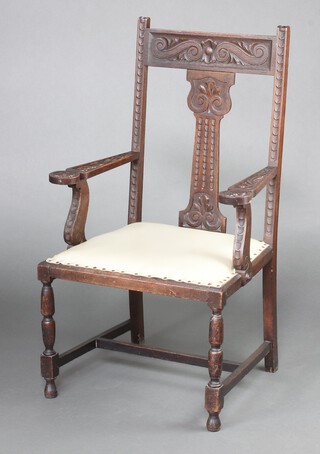 A carved oak slat back carver chair with upholstered seat, raised on turned supports 114cm h x 68cm w x 55cm d 