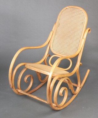 A beech framed Thonet style rocking chair 100cm (slight hole to back caned panel)