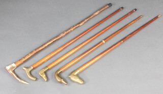 A walking stick with stag horn handle and 4 other walking sticks with brass handles 