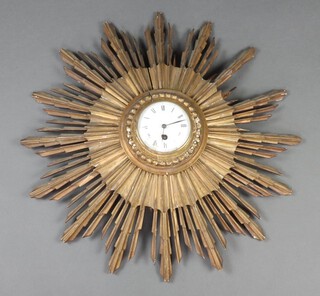 A sunburst time piece with 10cm dial, contained in a 62cm carved wooden frame, (some damage in places) 