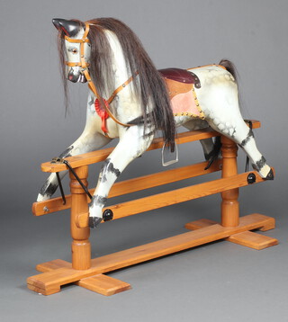 A dapple grey rocking horse, raised on a pine base 94cm h x 121cm w x 39cm d 