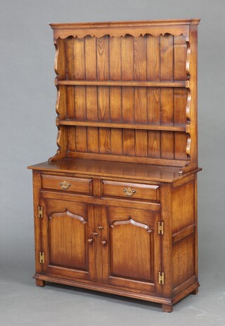 Titchmarsh and Goodwin, a Georgian style oak dresser with moulded cornice, the raised back fitted 2 shelves above 2 drawers, the base fitted a cupboard enclosed by panelled doors, raised on square feet 180cm h x 107cm w x 46cm d 