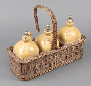 Three Earthenware whisky ewers in a wicker carrying basket