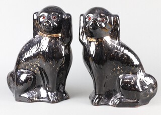 A pair of Slater Burslem black glazed figure of Spaniels with glass eyes and gilt decoration 30cm 