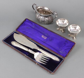 A pair of silver plated fisher servers cased, a sugar bowl and a pair of Empire style table salts 