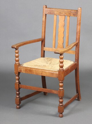 An Art Nouveau light oak slat back dining chair with woven rush seat