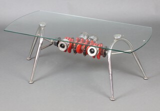 A chrome and plate glass coffee table, the base formed from 4 pistons 44cm x 100cm x 60cm