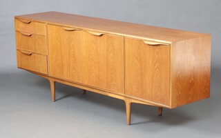 Mid-century, a McIntosh teak sideboard fitted three long drawers flanked by double cupboard and a cocktail unit raised on turned supports, 76cm x 202cm x 45cm 