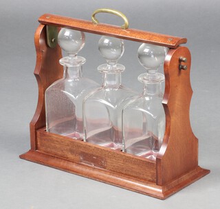 A 20th Century three bottle tantalus in a mahogany case