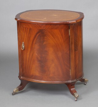 An oval mahogany cabinet with panelled door 79cm x 60cm x 45cm