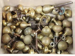 A collection of various gilt metal door knobs contained in a plastic box 