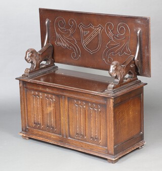 An oak monks bench with lion mask handles, hinged lid and linen fold decoration 75cm h x 104cm w x 45cm d 