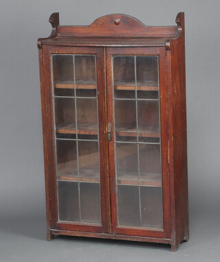 An Edwardian oak display cabinet with raised back, enclosed by lead glazed panelled doors 107cm x 72cm w x 24cm d 