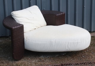 A "leather" wicker effect curved conservatory day bed 62cm h x 153cm w x 100cm d (some staining to cushion)