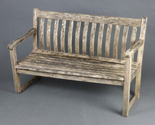 A well weathered slatted hardwood garden bench 81cm h x 122cm w x 53cm d (rot to left hand stretcher) 