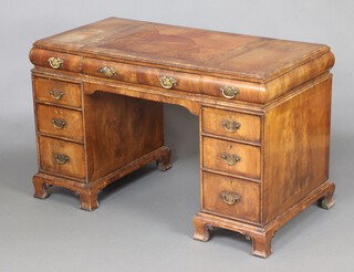 A Queen Anne style walnut kneehole desk with leather inset writing surface fitted 1 long and 8 short drawers, raised on ogee bracket feet 75cm h x 122cm w x 62cm d 