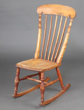 A 19th Century beech Windsor stick and rail back rocking chair with solid seat and H framed stretcher 97cm h x 58cm x 36cm d 