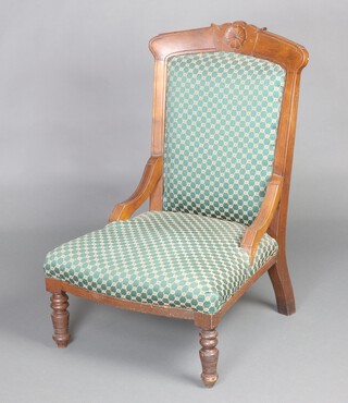 A Victorian carved walnut show frame nursing chair, seat and back upholstered in green material, raised on turned supports 94cm h x 59cm w x 58cm d (seat 25cm x 40cm) 