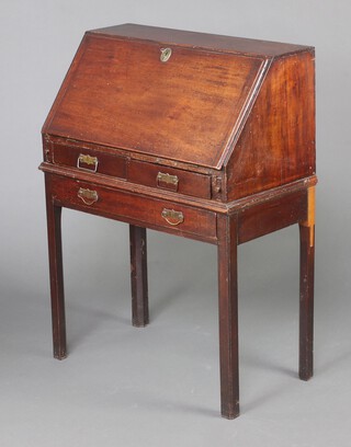 A Georgian mahogany bureau on stand, the fall front revealing a fitted interior above 2 short and 1 long drawer with later handles, raised on square tapered supports 104cm h x 76cm w x 42cm d 