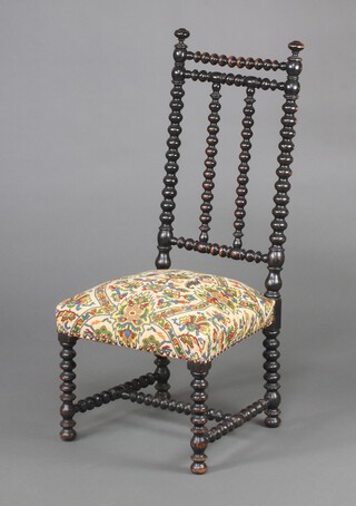 A Victorian ebonised bobbin turned nursing chair with tapestry patterned upholstered seat, raised on turned supports 96cm h x 43cm w x 40cm d 