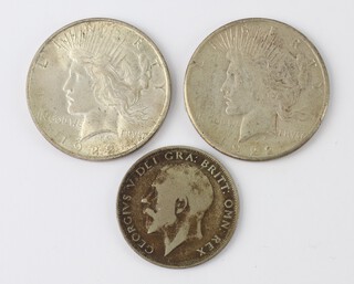 Two US silver peace dollars dated 1922 and a George V 1921 half crown 