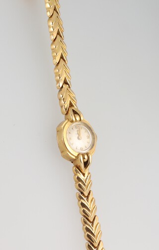 A lady's 18ct yellow gold Omega wristwatch on a ditto bracelet, movement numbered 114373, case no. 10869090, in working order, 18.4 grams including the glass 